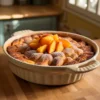 Can you add canned fruit to bread pudding – Delicious Homemade Dessert? A freshly baked bread pudding topped with canned peaches, showcasing how you can add canned fruit to bread pudding.