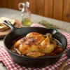 Amish Chicken breast searing in a cast-iron skillet with herbs and butter